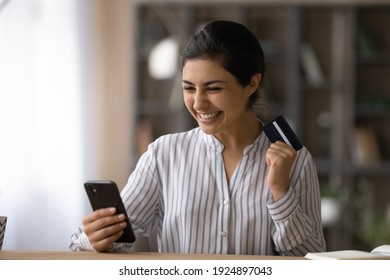 Overjoyed Millennial Indian Woman Use Smartphone Shopping Online With Credit Card. Excited Young Mixed Race Female Buyer Get Good Sale Deal Or Promotion Offer Buy On Internet On Cellphone Gadget.