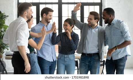 Overjoyed multiracial colleagues have fun celebrate shared business victory or win at workplace, happy diverse multiethnic businesspeople engaged in funny teambuilding activity in office together - Powered by Shutterstock