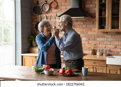 Overjoyed Old Caucasian Man And Woman Have Fun Cook Healthy Delicious Breakfast Lunch At Home Kitchen Together. Happy Mature Husband And Wife Enjoy Good Retirement Weekend, Prepare Food In Own Home.