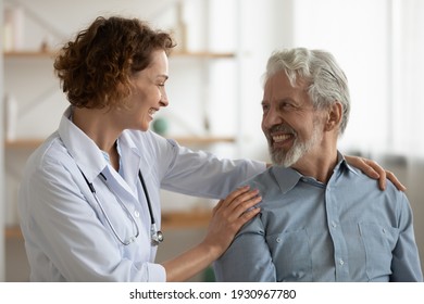 Overjoyed Senior Caucasian Grey-haired Man With Caring Young Female Nurse Or Caregiver At Home Visit. Smiling Mature Male Patient Get Supported Cared By Woman Doctor. Geriatrics, Healthcare Concept.