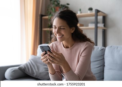 Overjoyed Woman With Healthy Toothy Smile Looking At Phone Screen Close Up, Sitting On Couch In Living Room, Happy Laughing Girl Using Smartphone, Chatting In Social Network, Having Fun With Gadget