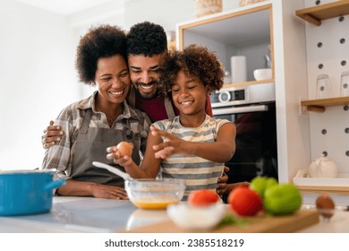 Overjoyed young african american family with kid have fun cooking at home together, - Powered by Shutterstock