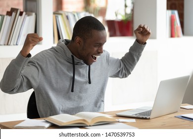 Overjoyed Young African American Male Student Celebrating Unbelievable High Score Evaluation Exam Results, Getting High Paid Job Offer Or Internship Proposition. Euphoric Guy Reading Win Notification.