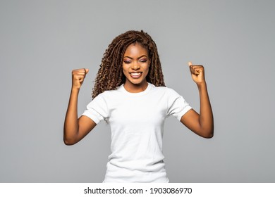 Overjoyed young african american woman screaming with joy celebrating victory win success on white background, happy excited black girl rejoicing triumph feeling winner