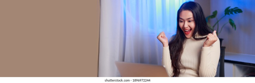 Overjoyed young Asian woman look at laptop screen feel euphoric with online lottery win or success, excited woman triumph read pleasant good news in email on computer, luck concept.