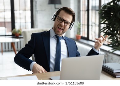 Overjoyed Young Caucasian Male Office Employee In Suit Wear Headset Listen To Rock Music At Workplace, Happy Businessman In Headphones Relax Have Fun Enjoy Good Quality Audio, Stress Free Concept