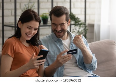 Overjoyed young couple man and woman checking credit card balance, celebrating success close up, using smartphone, customers excited by money refund or shopping offer, reading good news in message