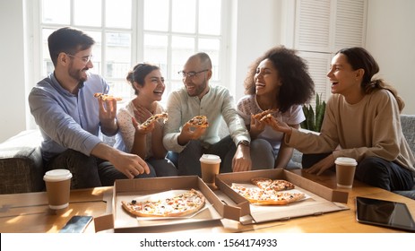 Overjoyed young diverse buddies eating ordered pizza for home party. Happy mixed race young friends enjoying spending free weekend time together, laughing, joking, communicating, having fun. - Powered by Shutterstock