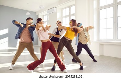 Overjoyed young diverse dancers team in casual clothes and glasses have fun performing together in studio. Smiling millennial group or crew dancing preparing for concert. Entertainment and hobby. - Powered by Shutterstock