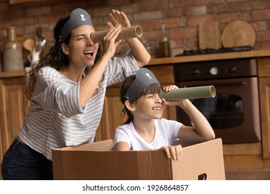 Overjoyed Young Hispanic Mother And Little 7s Daughter Have Fun Playing Pirates Game At Home Together. Playful Happy Latino Mom Or Nanny And Small Girl Child Engaged In Funny Activity On Weekend.