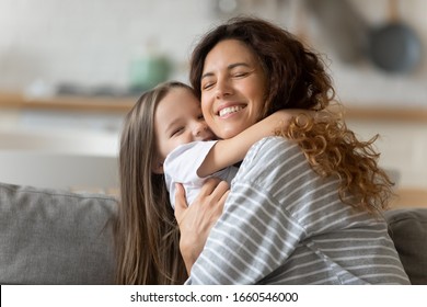 Overjoyed young mother relax on couch have fun cuddling with cute little preschooler daughter at home, happy smiling mom and small funny girl child have fun hug and embrace rest together on sofa - Shutterstock ID 1660546000