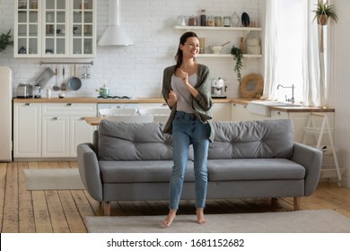 Overjoyed young woman enjoy free leisure weekend at home dancing listen to music in living room, smiling happy millennial female have fun moving to rhythm being active in modern studio home - Powered by Shutterstock