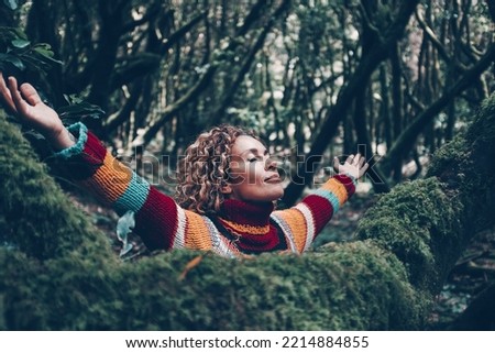 Overjoyed young woman outstretching and opening arms for joyful emotions. Happy female people loving nature and trees at the park. Green color. Adventure and alternative tourism. Environment concept