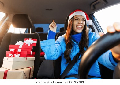 Overjoyed young woman in Santa Hat driving car with Xmas gift boxes nearby and enjoy music, singing song feeling enjoyment of winter holiday preparation - Powered by Shutterstock