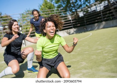 Overjoyed young women celebrating victory on football field. Sportswomen in uniforms cheering, congratulating teammate. Screaming happily. Sport, leisure, active lifestyle concept - Powered by Shutterstock