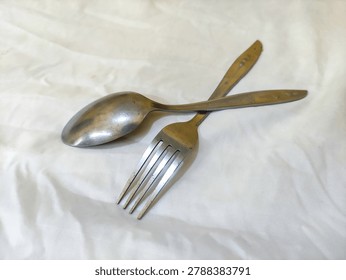Overlapping Spoon and Fork on White Background