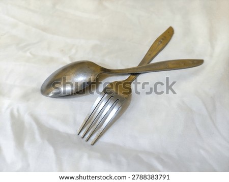 Overlapping Spoon and Fork on White Background