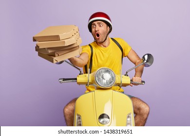 Overload busy delivery driver stares at stack of falling pizza boxes, has problem while hurries, being short of time, sits at motorbike against purple background. Oh no, risk of loosing balance.