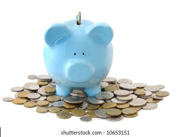 Overloaded blue piggy bank, surrounded by gold and silver coins.