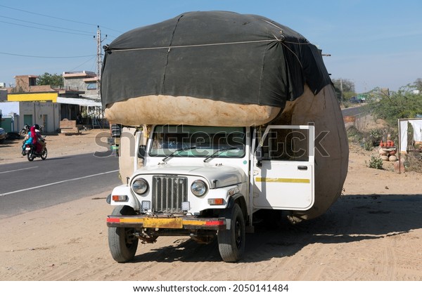An overloaded truck\
with goods. India.