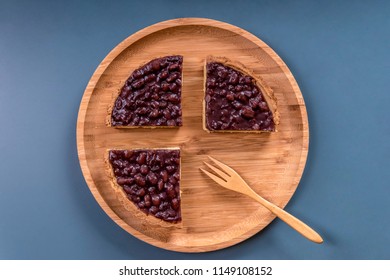 Overlook The Red Bean Pies And The Wooden Fork On The Round Wooden Plate With Navy Blue Background