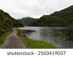 Overlooking a Scottish lake with a path between the green hillside.