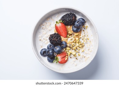 Overnight oatmeal with fresh berries and nuts, white background, top view. Healthy breakfast concept. - Powered by Shutterstock