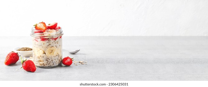 Overnight Oats, Chia Pudding with Fresh Strawberry, Banana and Chia Seeds in Jars on Grey Background, Healthy Snack or Breakfast - Powered by Shutterstock