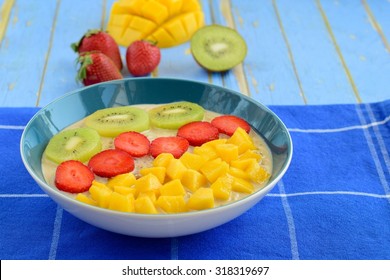 Overnight Oats Decorated With Mango, Strawberry And Kiwi. Blue Background