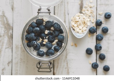 Overnight Oats With Soaked In Coconut Milk With Fresh Bluberry On Wooden Table, Top View. Healthy Breakfast