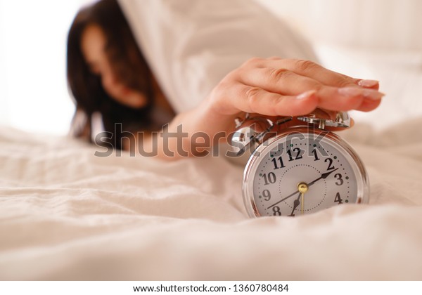 Oversleep woman waking up late turning off alarm\
clock. Morning routine, early awakening, lack of sleeping, time\
line concept
