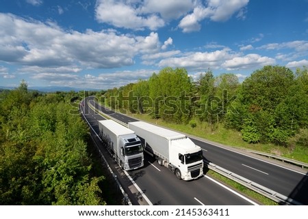 Overtaking trucks on the highway in the forested landscape