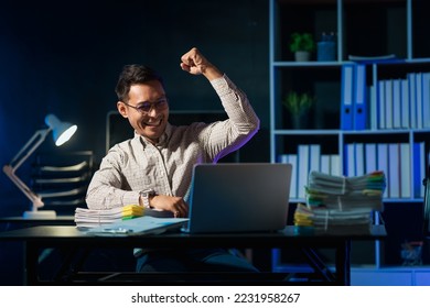 Overtime work concept, Handsome asian business man working late at night in office workplace. - Shutterstock ID 2231958267