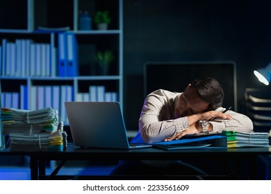 Overtime work concept, Handsome asian business man working late at night in office workplace. - Shutterstock ID 2233561609