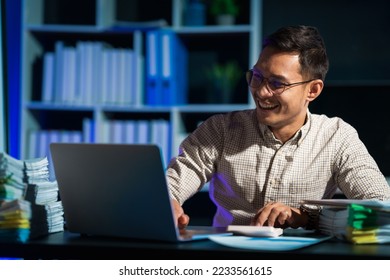 Overtime work concept, Handsome asian business man working late at night in office workplace. - Shutterstock ID 2233561615