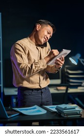 Overtime work concept, Handsome asian business man working late at night in office workplace. - Shutterstock ID 2233561617
