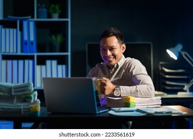 Overtime work concept, Handsome asian business man looking football league on laptop with beer glass, soccer fans. - Shutterstock ID 2233561619