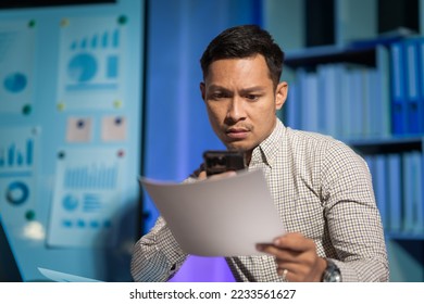 Overtime work concept, Handsome asian business man working late at night in office workplace. - Shutterstock ID 2233561627