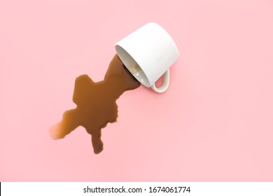Overturned cup of coffee on color background