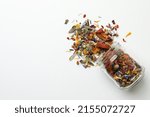 Overturned glass jar with dry herbal tea on white background, top view. Space for text