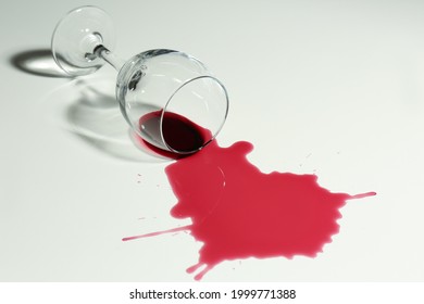 Overturned Glass And Spilled Wine On White Background