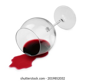 Overturned glass and spilled wine on white background