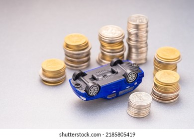 An Overturned Small Car With A Stack Of Money Around, Car Insurance Protection, Car Accident, And Finance Concept