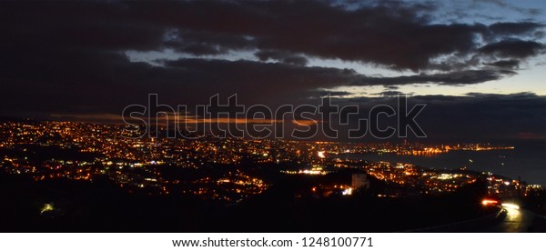 Overview of Beirut at dusk while
lights are on, with tracks on cars lights on motion on
foreground