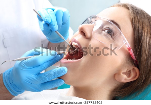 Overview of dental caries\
prevention.Woman at the dentist\'s chair during a dental\
procedure