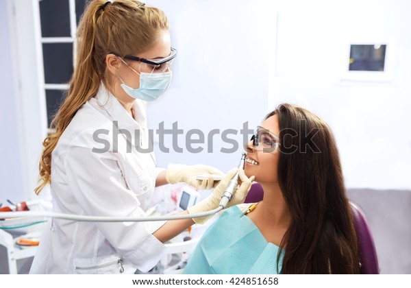 Overview of dental caries\
prevention.Woman at the dentist\'s chair during a dental procedure.\
Beautiful Woman smile close up. Healthy Smile. Beautiful Female\
Smile