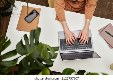 Overview of hands of young businesswoman or student typing on laptop keyboard by desk while working over presentation - Shutterstock ID 2122757807