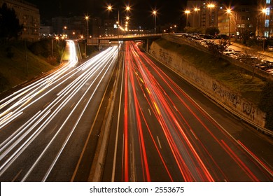 overview of a highway at night with multiple light streaks