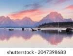 Overview of Jackson Lake with colorful boats in foreground before sun rise viewing from signal Mountain campground at Grand Teton National Park, Wyoming USA.