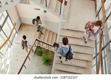 Overview of teenage students going up and down staircase in corridor while leaving for home or another university building